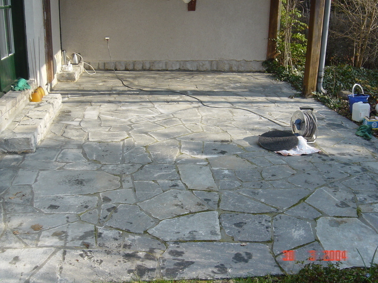 Schiefer-Terrasse vorher – verschmutzt mit Moos und Kalkflecken